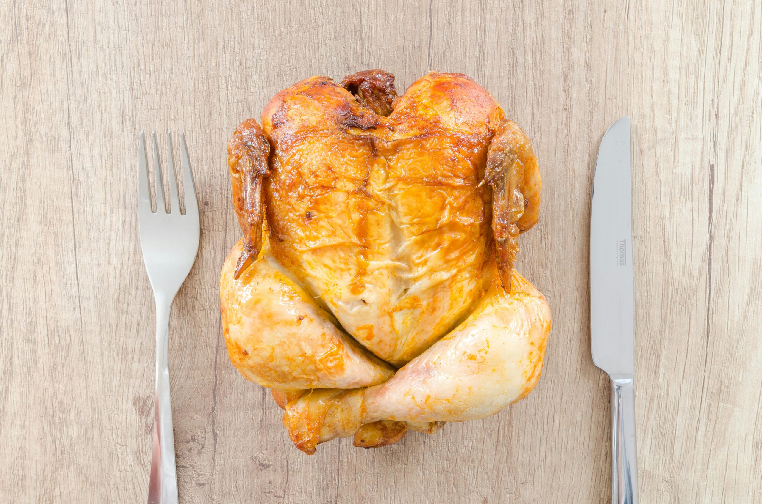Budget Dinner Plan for Family of 6 - Roasted Chicken with fork and knife around it